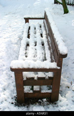 Legno vuota una panchina nel parco coperto di neve profonda Foto Stock