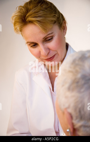 Donne medico o infermiere ascolta il suo paziente. Foto Stock