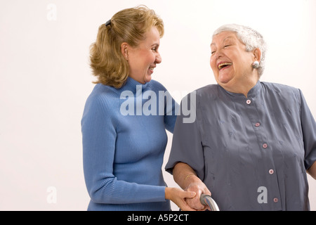 Visita (infermiere o parente o amico) ha una risata con donna senior. Foto Stock