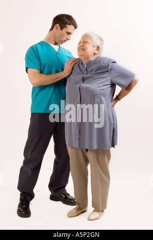 Senior paziente femmina di spiegare esattamente dove mi fa male. Vi. Lì, ouch. Foto Stock