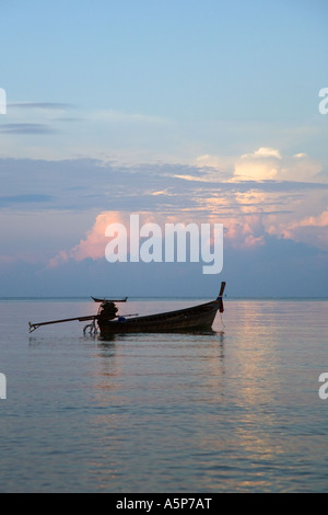 Barca solitaria a navi da pesca al di ancoraggio sul placido mare calmo all'alba Krabi Beach Resort Krabi mare delle Andamane Thailandia Foto Stock