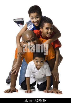 Padre posa con tre figli Foto Stock