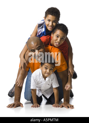 Padre posa con tre figli Foto Stock