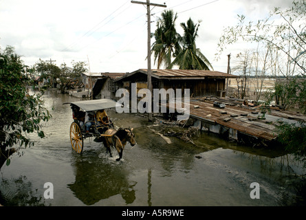 MOUNT PINATUBO DISASTER FEBBRAIO 1991 abitante TORNARE ALLA LORO parzialmente sommerso in casa PARULOG, Luzon, Filippine Foto Stock