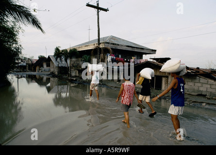 MOUNT PINATUBO DISASTER FEBBRAIO 1991 abitante TORNARE ALLA LORO parzialmente sommerso in casa PARULOG, Luzon, Filippine Foto Stock