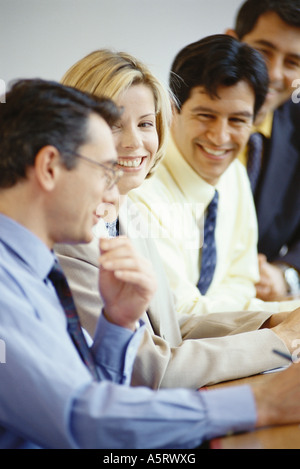 Business Associates seduta a tavola, ridendo Foto Stock