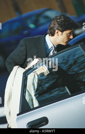 Imprenditore in piedi dalla portiera aperta Foto Stock