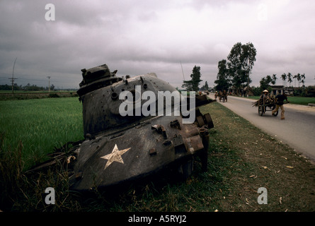 Il Vietnam, lungo l'autostrada 1 tra la tonalità di Quang Tri visto che resta di un serbatoio americano GLI AGRICOLTORI CON CARRELLI PUSH passando da 1985 Foto Stock