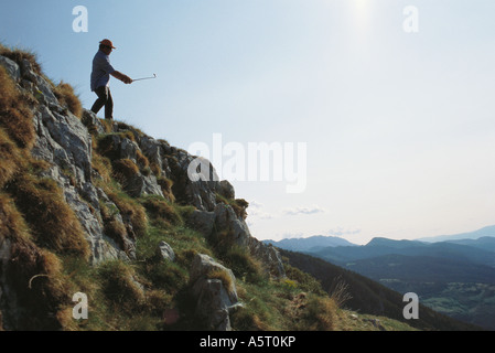 Il Golfer in piedi nel paesaggio scoscese Foto Stock
