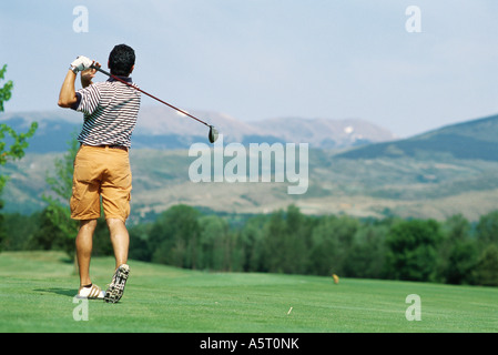 Il Golfer oscillante e paesaggio montuoso in background Foto Stock