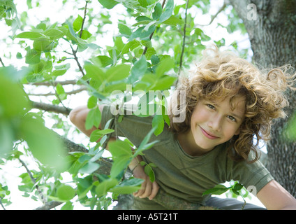 Ragazzo nella struttura ad albero, sorridente in telecamera Foto Stock