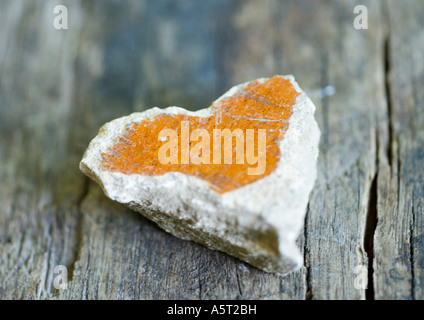 Cuore di pietra sagomato sulla superficie di legno Foto Stock