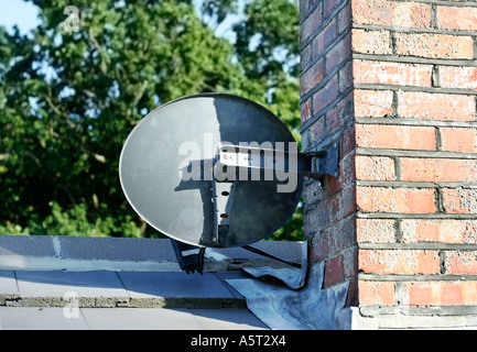 Home parabola satellitare collegato ad un camino di mattoni. Regno Unito Foto Stock