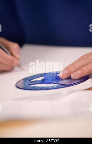 Young Teen boy facendo matematica di lavoro mediante un goniometro Foto Stock