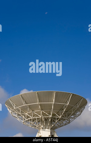 Un radiotelescopio punti in un inizio di mattina cielo dove la Luna è ancora presente Foto Stock