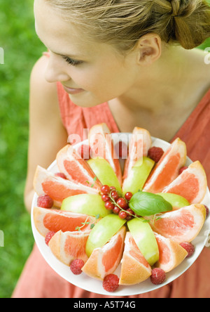 Donna tenendo la piastra pieno di frutta a fette, ad alto angolo di visione Foto Stock