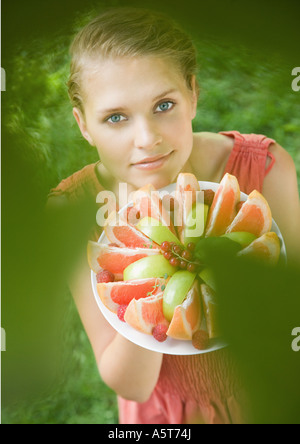 Donna tenendo la piastra pieno di frutta a fette, ad alto angolo di visione Foto Stock