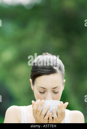 Donna di bere dalla ciotola Foto Stock