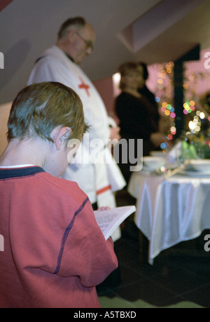 La Polonia, la vigilia di Natale, ragazzo leggere la verità del Vangelo Foto Stock