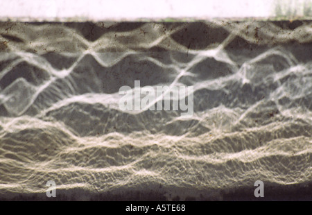 Le onde di un fiume riflettendo su una parete Foto Stock