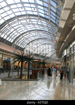 Persone passeggiata coperta in passato le palme sotto un lucernario con soffitto a volta al Millenia Mall vicino a Orlando FL Foto Stock