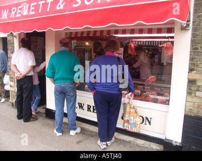 Coda di persone al di fuori del tradizionale negozio di macellaio Wickham Market Suffolk in Inghilterra Foto Stock