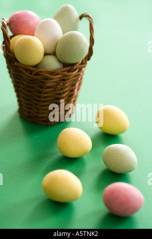 Le uova di pasqua cesto con del marzapane colorato dolci su sfondo verde Foto Stock