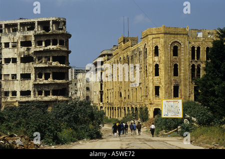 Persone che camminano davanti agli edifici distrutti dalla guerra civile libanese, Beirut, Libano. 1995. Foto Stock