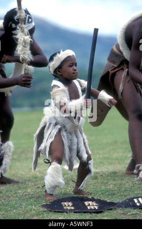 Giovane ragazzo ballando con Zulu ballerini tradizionali KwaZulu Natal Midlands Sud Africa Foto Stock