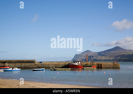 Barche jetty calma acqua blu nel porto di Penrhyn Nefyn porto di pesca e vista su tutta Porth Nefyn Bay su Lleyn Peninsula Wales UK Foto Stock