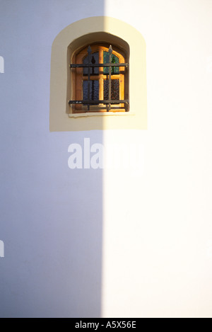 Il mezzogiorno ombra al di sopra del centro di un andamento arcuato la finestra della chiesa sull'isola di Corfu Grecia Foto Stock