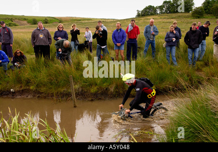 Concorrente nel mondo annuale Mountain Bike Bog Snorkelling campionati a Llanwrtyd Wells Powys entrando nel water REGNO UNITO Foto Stock