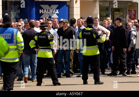 Gli ufficiali di polizia manganelli tracciata vegli su di un gruppo di appassionati di calcio nel centro di Cardiff in città per la finale di FA Cup Foto Stock