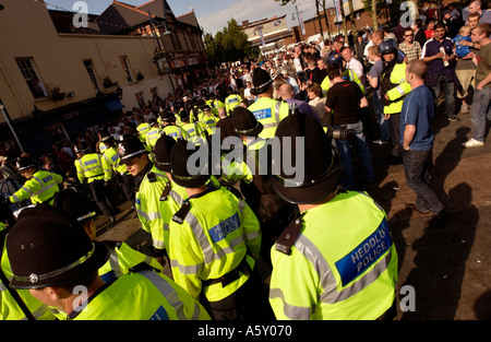 Gli ufficiali di polizia manganelli di richiamare durante guasto tra football soccer fans di bere alcolici in Mill Lane Cardiff South Wales UK Foto Stock