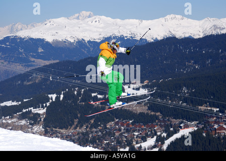 Sciatore eseguendo acrobazie aeree con vista della montagna e valle in background Foto Stock