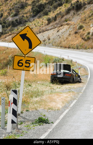 Auto rottamata a piegare subito dopo la velocità segno di avvertimento Foto Stock
