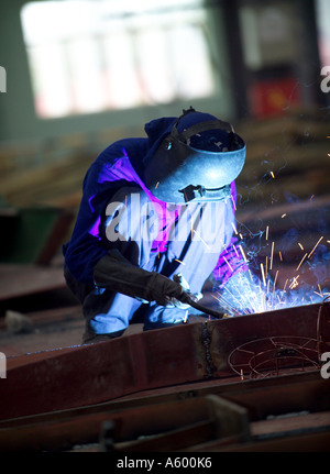 Saldatore ad arco, cantiere navale vietnamita lavoratore, nel laboratorio di ingegneria, Asia Foto Stock