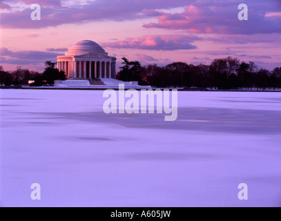 Una vista del Jefferson Memorial attraverso un congelati Tidal Basin contro una tonalità di rosa di una regolazione del sole Foto Stock