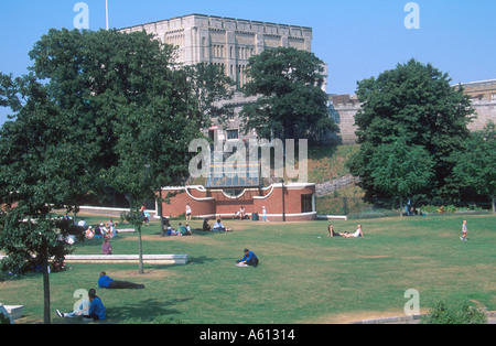 La gente seduta su erba a castle mall giardino con vista del castello Norwich Norfolk England Regno Unito Foto Stock
