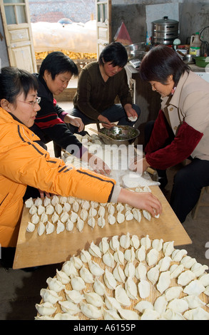 Donne che fanno la preparazione tradizionale dim sum gnocchi Cinesi in agriturismo cucina, Provincia di Shandong, Cina Foto Stock