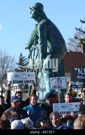 I pescatori commerciali rally contro federale regole di pesca intorno ai pescatori statua commemorativa in Gloucester Massachusetts Foto Stock