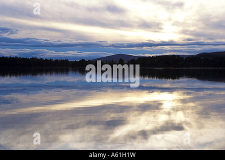 Immagine di panorama di un tramonto in inverno sul Loch di Skene, Aberdeenshire con riflessi sull'acqua calma. Foto Stock