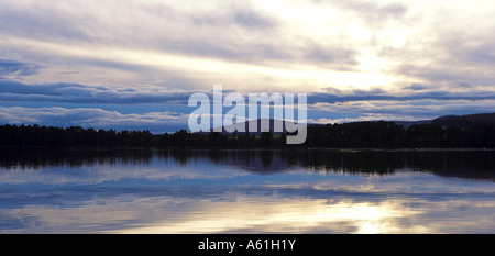 Panoramica di immagini di un inverno tramonto sul Loch di Skene, Aberdeenshire con riflessi sull'acqua calma. Foto Stock