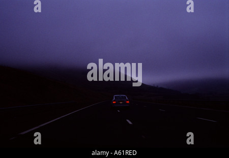 Nightfall e nebbia caduta sulla autostrada M6 a nord di Preston, Regno Unito. Foto Stock