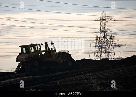 Bulldozer stagliano con tralicci lo spostamento delle ceneri volanti sul Coal Fired Uskmouth Power Station Newport Wales UK Foto Stock