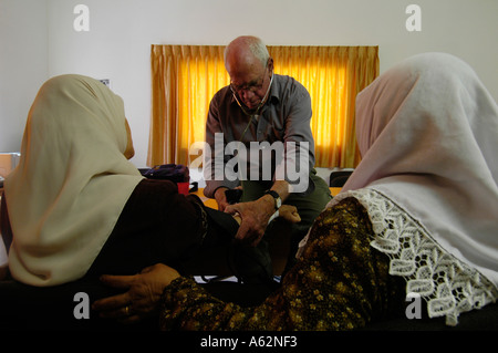 Un volontario israeliano dei PHR Medici per i diritti umani che controlla una donna palestinese durante una visita di una clinica mobile nella Cisgiordania Israele Foto Stock