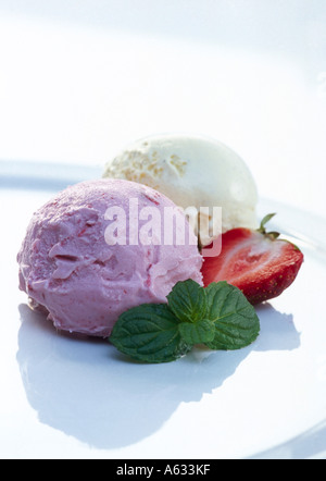 Gelato servito con fragola e foglie di menta sulla piastra Foto Stock