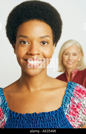 Ritratto di una giovane donna sorridente con una donna senior in background Foto Stock