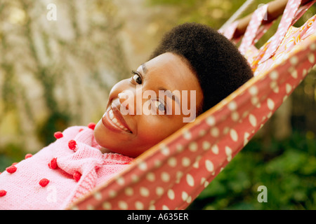 Ritratto di una giovane donna sorridente e giacente in una amaca Foto Stock