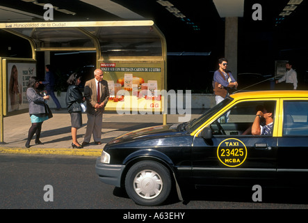 Persone l uomo e la donna in attesa presso la fermata degli autobus e taxi cab driver Buenos Aires Provincia di Buenos Aires Argentina America del Sud Foto Stock